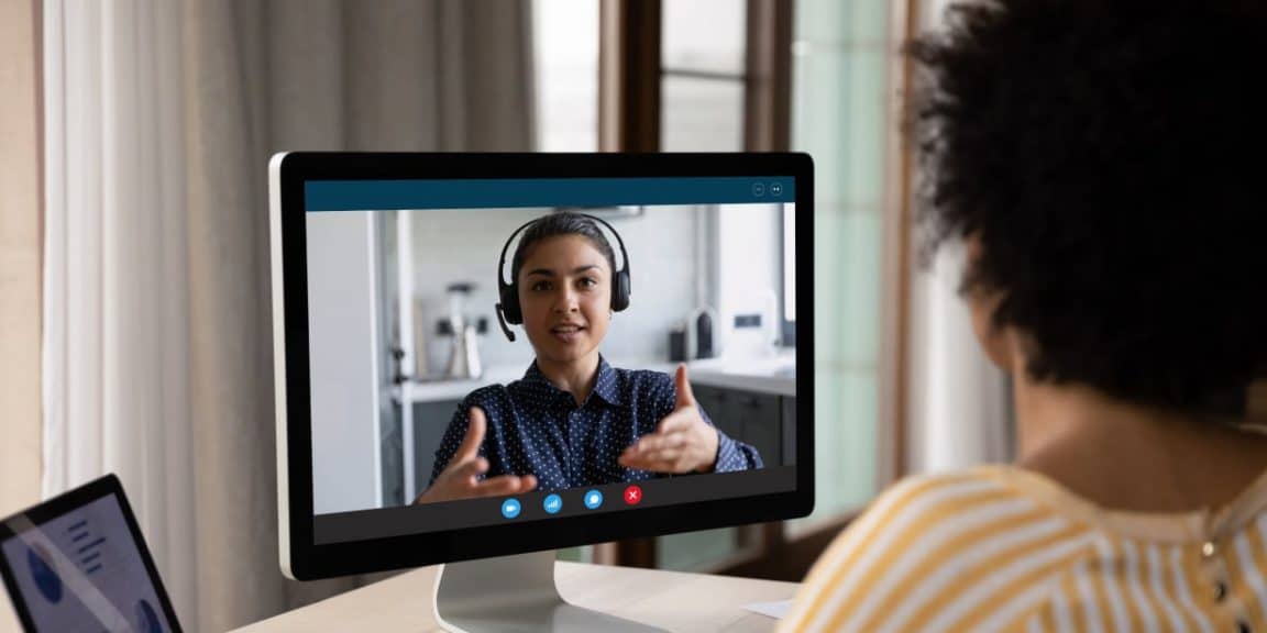 Funcionária do setor de pessoas atuando com recrutamento profissionais de ti, entrevistando candidata de uma vaga, por meio de vídeo chamada.