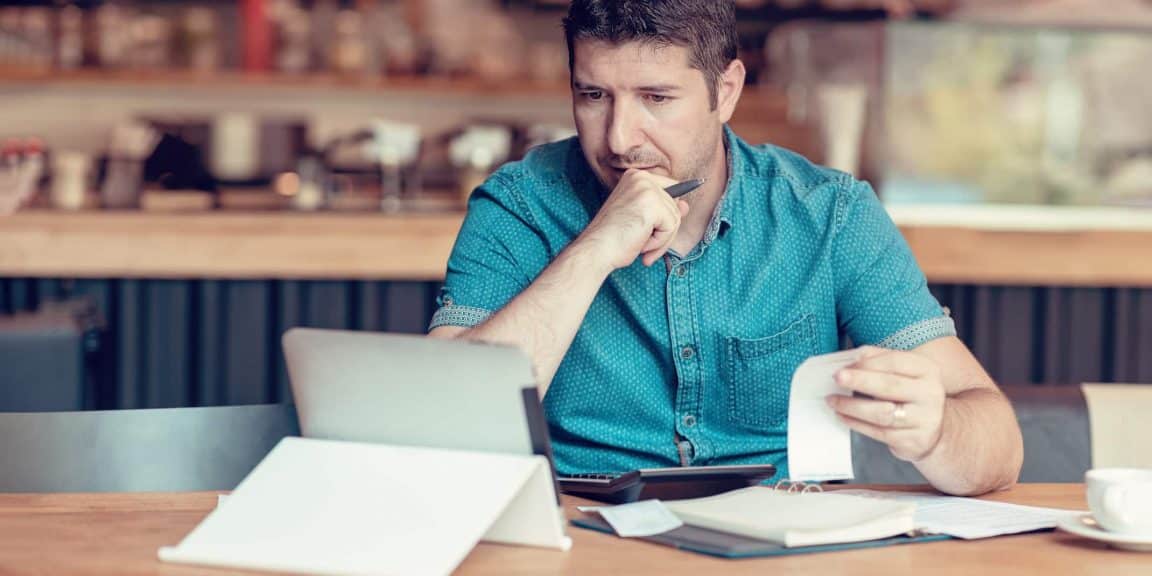 homem conferindo contas no tablet para calcular o simples nacional